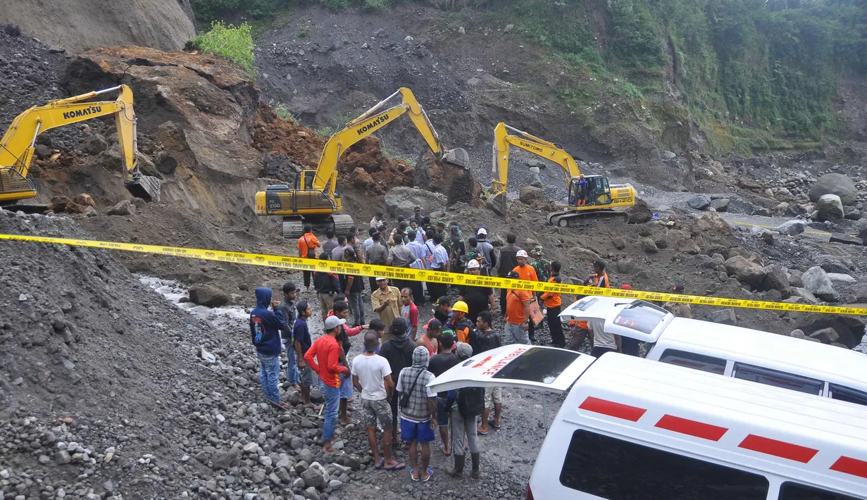 Petugas dibantu alat berat berusaha mencari korban tanah longsor di Magelang, Senin (18/12). Menurut pejabat setempat, delapan penambang tewas akibat longsor di lereng gunung berapi di pulau Jawa. (AFP Photo)