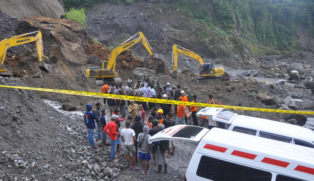Petugas dibantu alat berat berusaha mencari korban tanah longsor di Magelang, Senin (18/12). Menurut pejabat setempat, delapan penambang tewas akibat longsor di lereng gunung berapi di pulau Jawa. (AFP Photo)