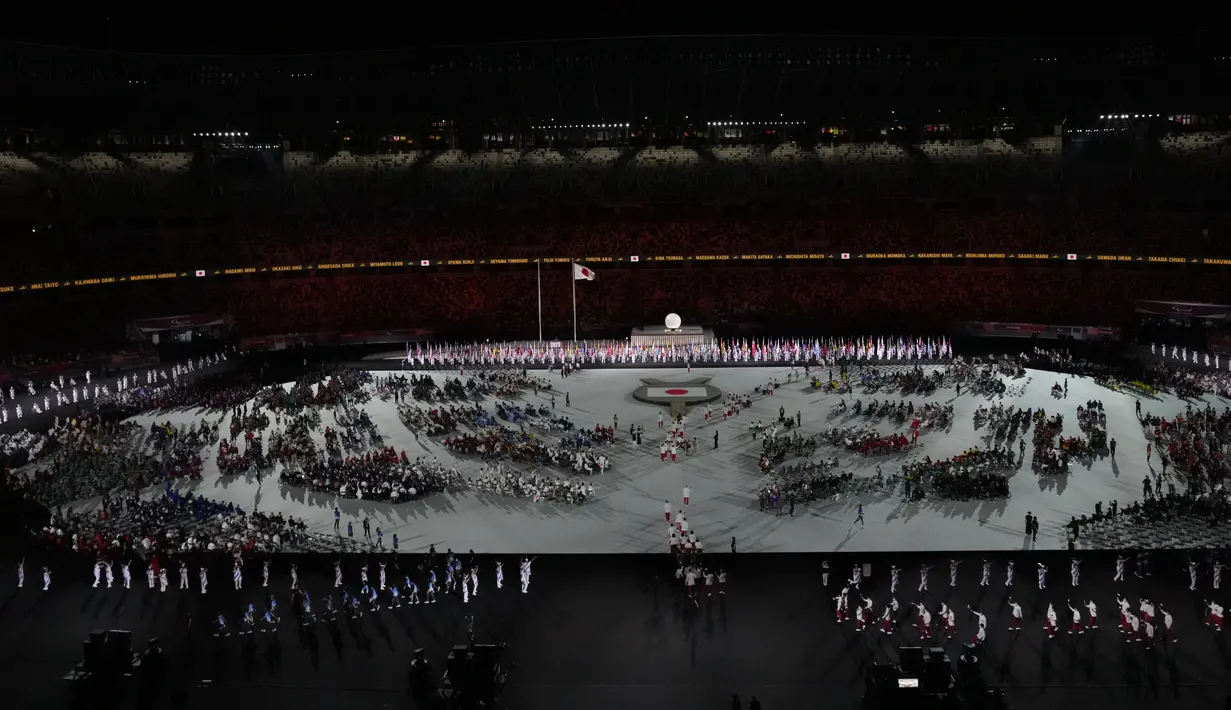 Para atlet berkumpul di stadion saat upacara pembukaan Paralimpiade Tokyo 2020 di Olympic Stadium, Tokyo, Selasa (24/8/2021) Bendera Afghanistan dikibarkan dalam defile tanpa kehadiran satu pun atletnya menyusul kondisi negaranya pasca dikuasai oleh Taliban. (AP Photo/Eugene Hoshiko)
