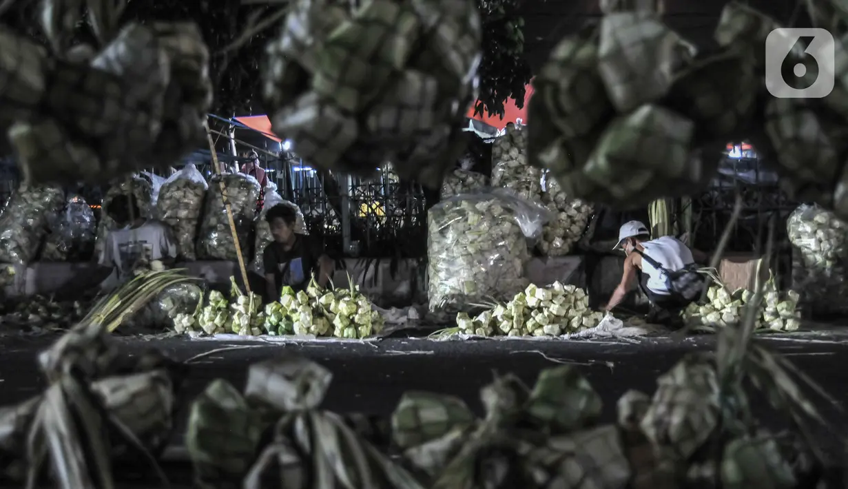 Pedagang bungkus atau tali ketupat saat menunggu pembeli di Pasar Klender, Jakarta Timur, Selasa (11/5/2021) malam. Tali ketupat di pasar ini dijual mulai dari Rp7.000 hingga Rp15.000 per ikat (10 buah), tergantung ukuran dan jenis daun kelapa. (merdeka.com/Iqbal S Nugroho)
