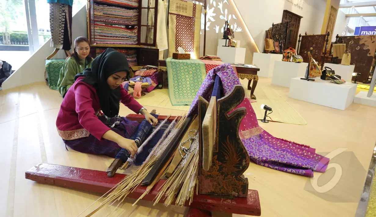 Seorang pengrajin membuat kain tenun pada Pameran Kerjasama Selatan-Selatan Triangular (KSST) di Jakarta Covention Center, Senin (19/4/2015). Pameran tersebut merupakan rangkaian dari acara KAA 2015. (Liputan6.com/Herman Zakharia)