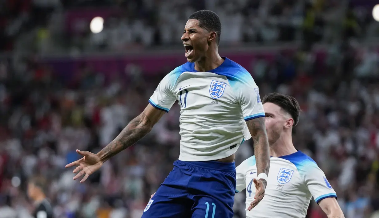 Penyerang Inggris Marcus Rashford merayakan gol pembuka yang dicetaknya ke gawang Wales pada pertandingan terakhir Grup B di Ahmad bin Ali Stadium, Rabu (30/11/2022) dini hari WIB. Timnas Inggris melangkah mantap ke Babak 16 Besar Piala Dunia 2022 sebagai juara grup. (AP Photo/Frank Augstein)