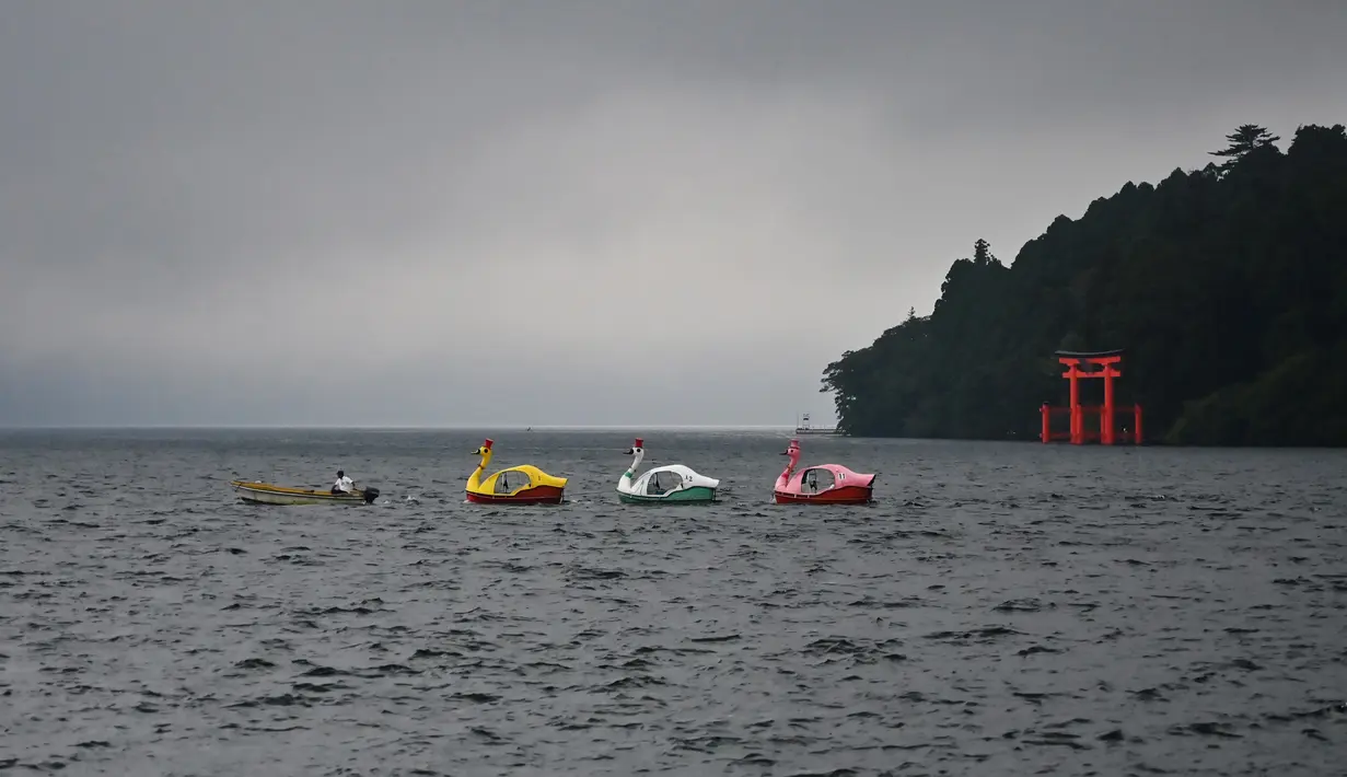 Dua kapal santai terlihat di atas Danau Ashi di prefektur Kanagawa, Jepang (11/9/2019). Daya tarik Danau Ashi yang paling terkenal adalah keindahan pemandangan Gunung Fuji yang tampak jelas jika dilihat dari Danau Ashi. (AFP Photo/Charly Triballeau)
