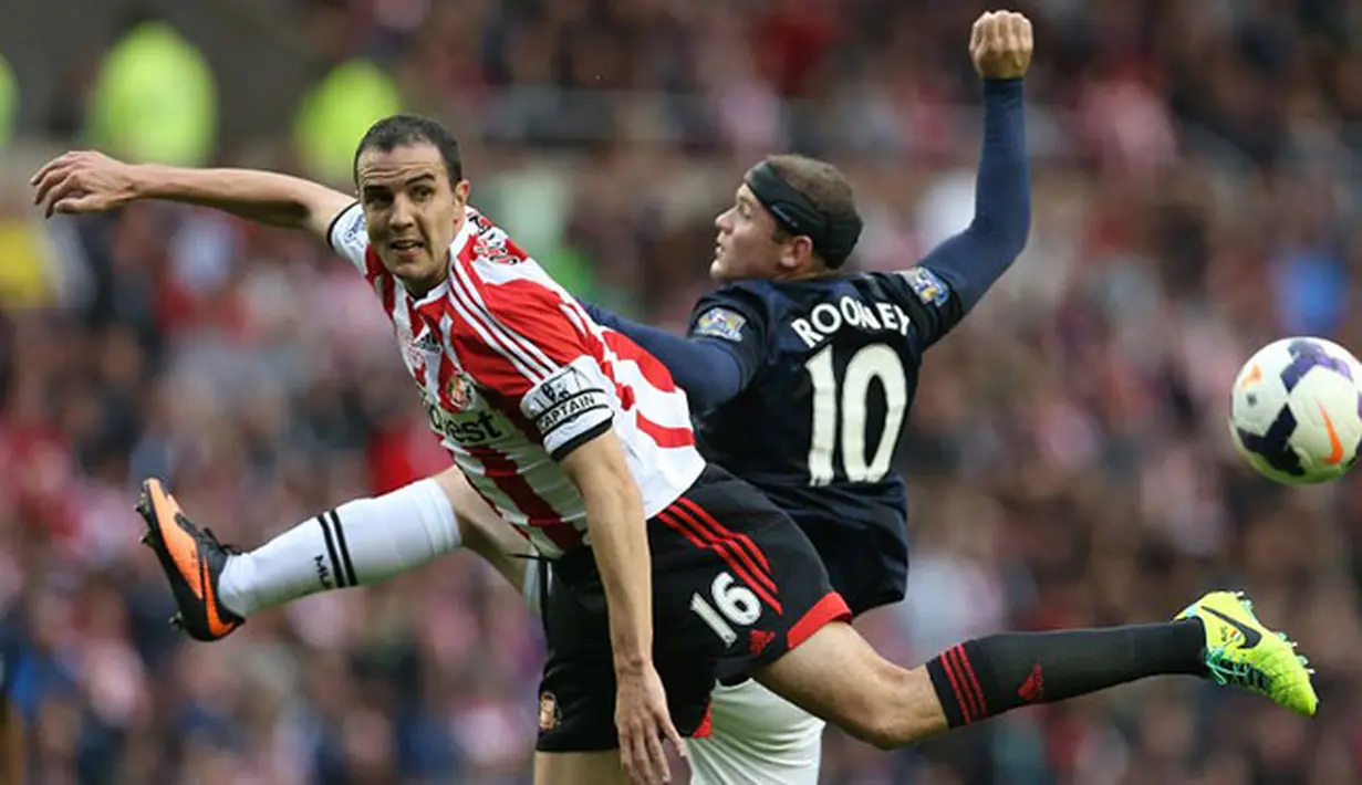 Wayne Rooney duel udara dengan J. O'Shea pada pertandingan sepak bola Liga Inggris antara Sunderland dan Manchester United di Stadion of Light di Sunderland (05/10/13). (AFP/Ian MacNicol)