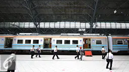 Petugas PT KAI berjalan disamping KRL saat dilakukan uji coba jalur di Stasiun Tanjung Priok, Jakarta, Senin (23/11). Stasiun seluas 3.768 meter persegi tersebut rencananya akan digunakan setelah renovasi Januari 2016. (Liputan6.com/Immanuel Antonius)