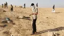 Seorang warga Irak membawa dua jenzah militan ISIS sebelum dimakamkan di Karmah, selatan Mosul, Irak (11/11). (REUTERS/Goran Tomasevic)