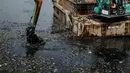 Kendaraan eskavator dan tongkang Dinas Tata Air DKI Jakarta mengeruk lumpur dan sampah dari Waduk Pluit, Jakarta, Selasa (11/12). Pengerukan ini dilakukan untuk menambah kedalaman waduk. (Liputan6.com/Faizal Fanani)
