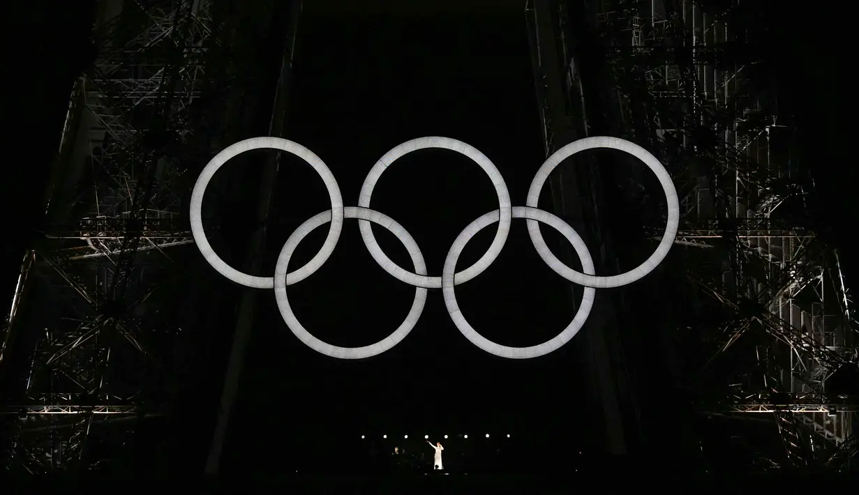 <p>Setelah penyalaan obor Olimpiade Paris 2024, sang Diva tampil di Menara Eiffel yang kilau cahaya dan berhias logo Olimpiade. (Loic VENANCE / POOL / AFP)</p>