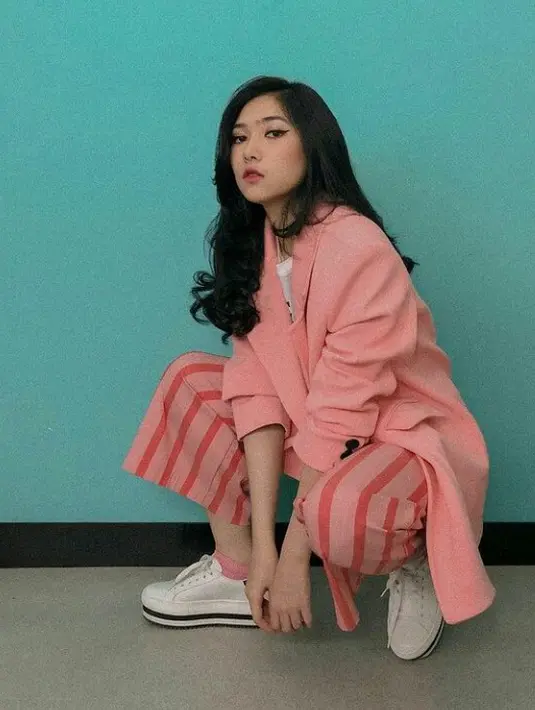 Blazer warna pink salmon juga cocok dipadu padankan dengan celana motif down stripe seperti Isyana. Agar menghasilkan look yang kasuak, lengkapi  penampilanmu dengan sneakers. (Instagram.com/Isyana Sarasvati).