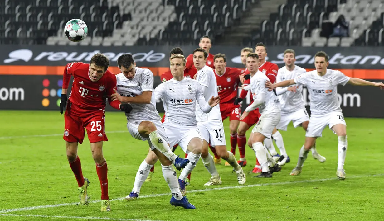Pemain Bayern Munchen Thomas Mueller (kiri) mencoba menyundul bola saat melawan Borussia Moenchengladbach pada pertandingan Bundesliga di Borussia Park, Moenchengladbach, Jerman, Jumat (8/1/2021). Bayern Munchen kalah 2-3. (AP Photo/Martin Meissner, Pool)
