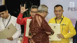 Ketua KPU Arief Budiman, memberikan berita acara parpol kepada Sekjen Partai Golkar Lodewijk Freidrich Paulus usai pengambilan nomor urut peserta pemilu 2019 di KPU, Jakarta, Minggu (18/2). (Liputan6.com/Faizal Fanani)