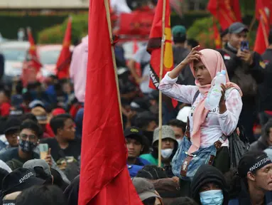 Pedagang asongan berjualan di tengah-tengah aksi unjuk rasa di kawasan Patung Kuda, Jakarta, Selasa (10/11/2020). Sejumlah pedagang mencoba peruntungan saat massa gabungan dari berbagai organisasi buruh dan mahasiswa berunjuk rasa menolak Omnibus Law UU Cipta Kerja. (Liputan6.com/Helmi Fithriansyah)