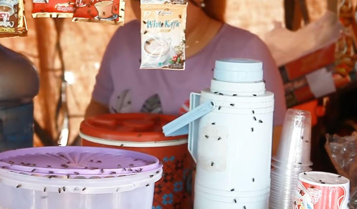 Barang dagangan yang ada di atas meja dikerubuti oleh lalat. Mulai dari gorengan yang baru saja jadi, hingga sisa minuman milik para pemulung.