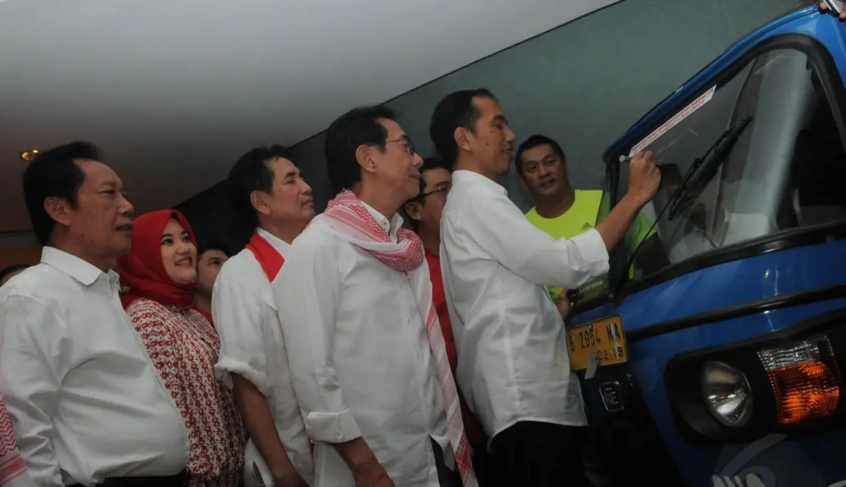 Minggu (1/6/14), Jokowi menandatangani Bajaj yang mengantarnya pada saat mengambil nomor urut di Kantor KPU. (Liputan6.com/Herman Zakharia)