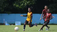 Arkhan Fikri (rompi oranye) melewati hadangan rekannya dalam latihan Arema FC di Lapangan ARG Malang. (Iwan Setiawan/Bola.com)