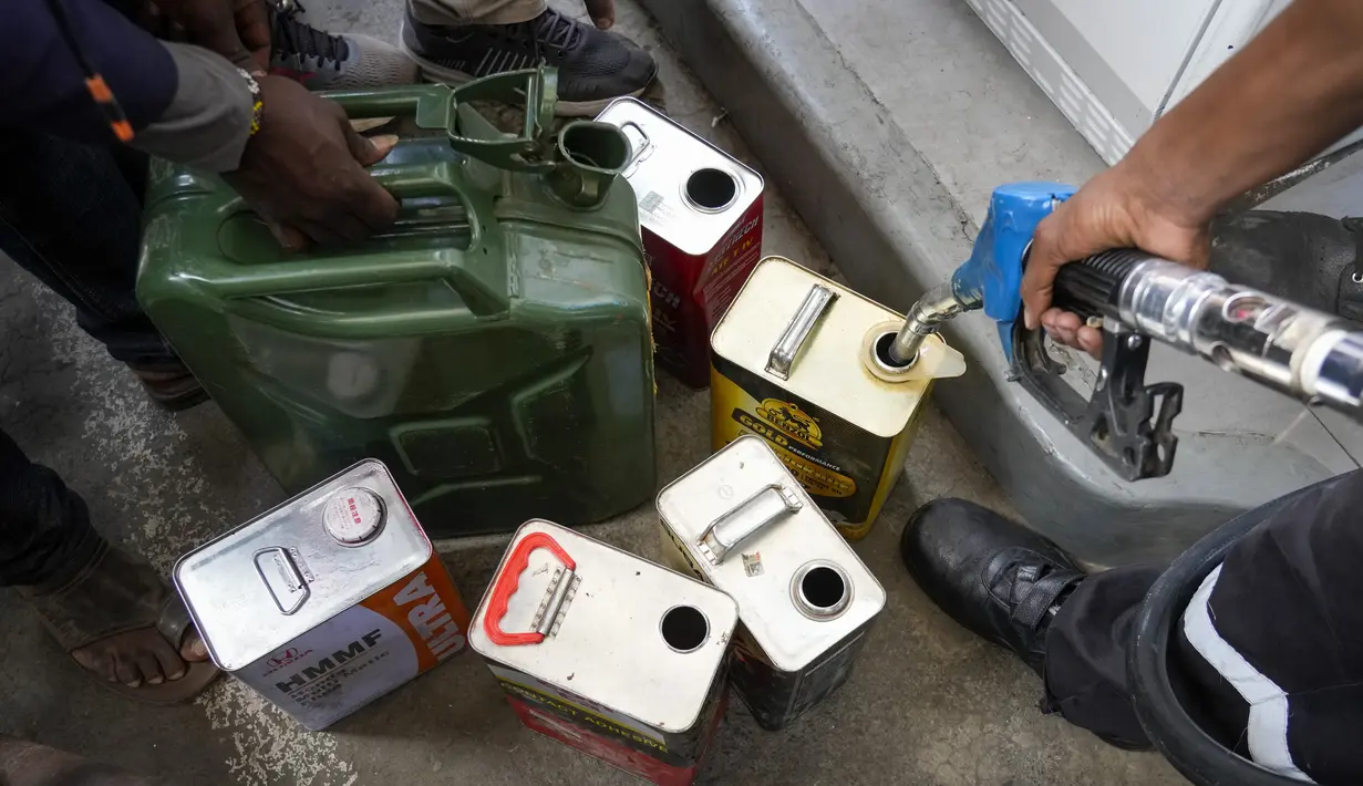 Petugas mengisi wadah dengan bahan bakar yang masih tersedia untuk pelanggan di salah satu pompa bensin di Hurlingham, Nairobi, 14 April 2022. Selama berminggu-minggu Kenya menderita kekurangan di pompa bensin dengan ada yang tidak memiliki bahan bakar sama sekali (AP Photo/Khalil Senosi)