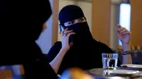 Seorang wanita bercadar berbicara di ponsel di sebuah kafe di Riyadh, Arab Saudi (6/10). (REUTERS/Faisal Al Nasser)