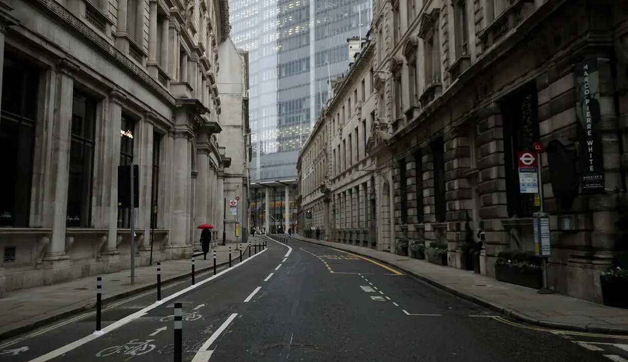 Seseorang berjalan dengan payung saat hujan ringan pagi pertama penerapan lockdown nasional ketiga di Kota London, Inggris, 5 Januari 2021. Penerapan lockdown nasional ketiga di Inggris berlangsung selama enam minggu. (AP Photo/Matt Dunham)