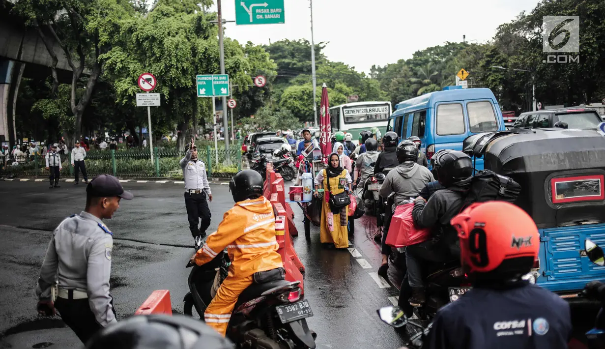 Petugas Dishub mengalihakan arus lalu lintas terkait Malam Munajat 212 di Medan Merdeka Barat dan Utara, Jakarta, Kamis (21/2). Masyarakat diimbau melintasi kawasan Monas sebelum pelaksanaan kegiatan. (Liputan6.com/Faizal Fanani)