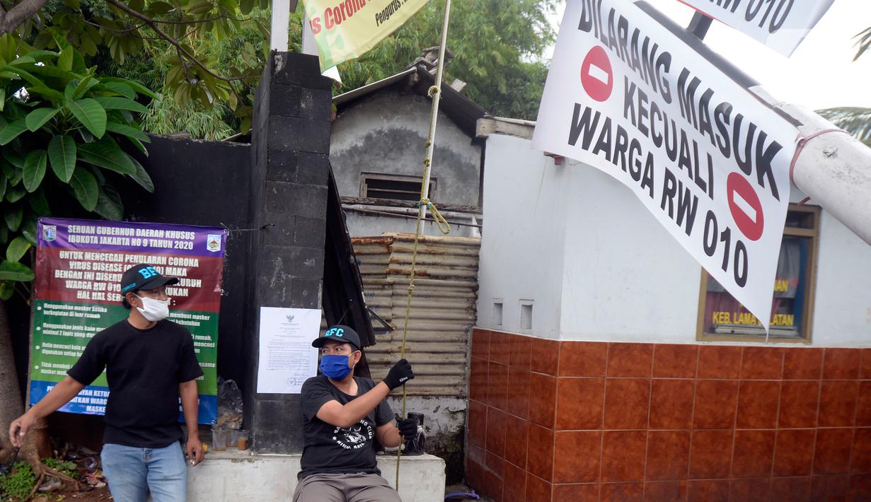 Sejumlah pemuda menjaga portal karantina wilayah menuju RW 10 di kawasan Tanah Kusir, Kelurahan Kebayoran Lama Selatan, Jakarta, Rabu (8/4/2020). Warga menerapkan akses satu pintu masuk pemukiman yang terdiri dari 12 RT tersebut untuk mencegah penyebaran corona COVID-19. (merdeka.com/Dwi Narwoko)