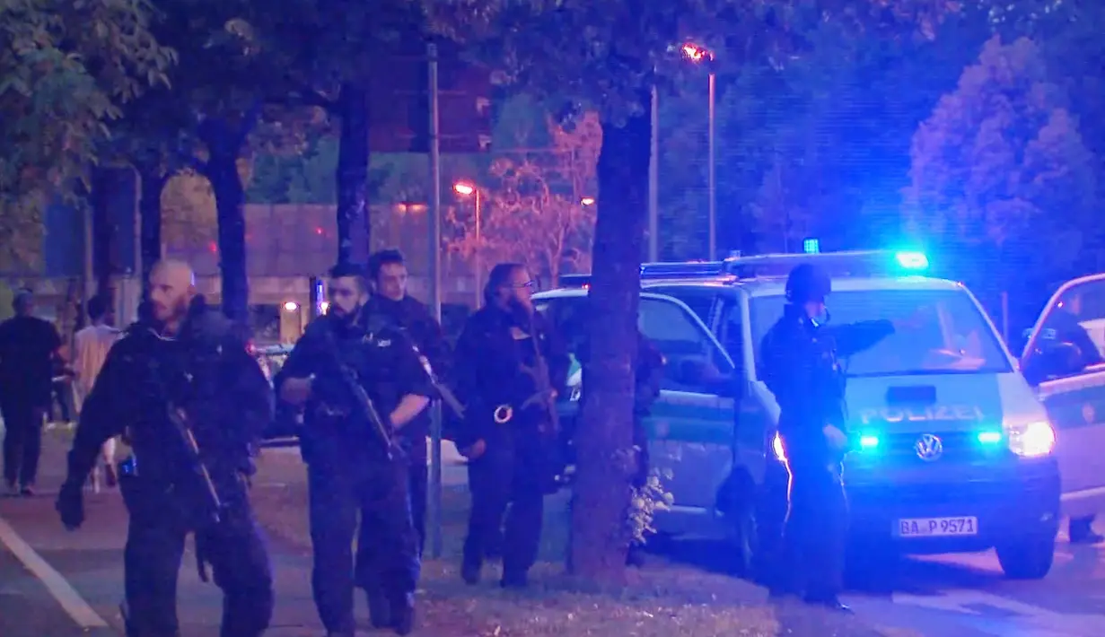 Polisi dengan senjata lengkap berjaga di dekat lokasi penembakan di pusat perbelanjaan Olympia di Munich, Jerman (22/7). Penembakan tersebut menewaskan sekitar 10 orang,termasuk pelaku.  (REUTERS / Reuters TV)