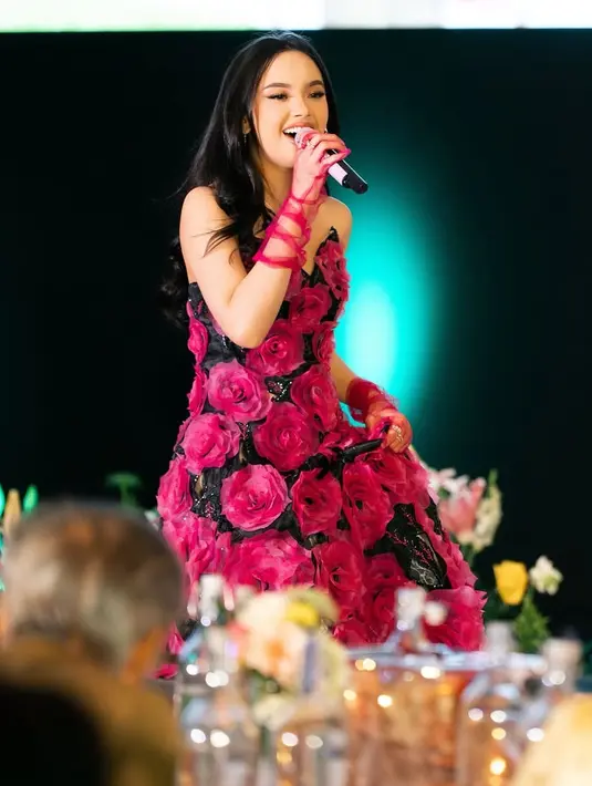 Ditata oleh Stylist, Wanda Harra, Lyodra tampil anggun mengenakan gaun panjang warna dasar hitam dengan hiasan bunga mawar 3D model besar warna fuschia.  [@randymartinnn]