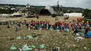 Petugas memungut sampah di depan Pyramid Stage pada akhir Festival Glastonbury di arena Worthy Farm, Inggris, 26 Juni 2017. Penyelenggaraan festival musik terbesar di dunia itu menyisakan sampah yang berserakan di seluruh arena. (OLI SCARFF/AFP)