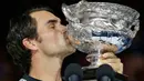 Petenis asal Swiss Roger Federer, mencium trofinya setelah berhasil meraih gelar Australia Terbuka 2017 di Melbourne, Minggu (29/1). Federer juga mencatatkan rekor sebagai petenis tertua yang memenangkan Grand Slam di usia 35 tahun (AP Photo/Aaron Favila)