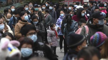 Warga berkumpul di kompleks perumahan untuk mendapatkan tes COVID-19 di Wuhan di provinsi Hubei China tengah, Selasa (22/2/2022). Wuhan, wabah besar pertama dari pandemi virus corona melaporkan lebih dari selusin kasus virus corona baru minggu ini. (Chinatopix via AP)