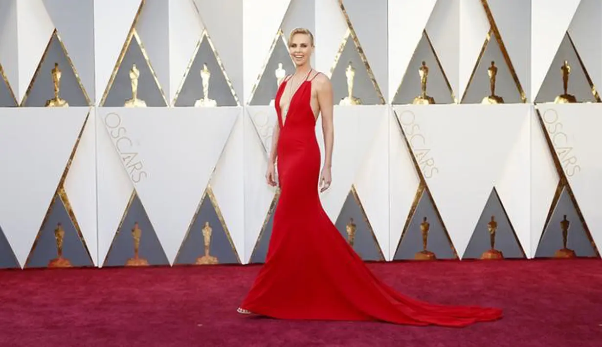  Charlize Theron berpose di red carpet Piala Oscar 2016 di Hollywood, California, Minggu (28/2). Bintang Mad Max itu tampil elegan dalam gaun merah rancangan Dior. (REUTERS/ Lucy Nicholson)