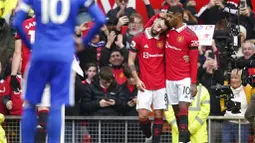 Pemain Manchester United, Marcus Rashford dan Bruno Fernandes merayakan gol yang dicetak ke gawang Leicester City pada laga Liga Inggris di Stadion Old Trafford, Minggu (19/2/2023). Marcus Rashford memborong dua dari tiga gol kemenangan Setan Merah. (AP Photo/Dave Thompson)