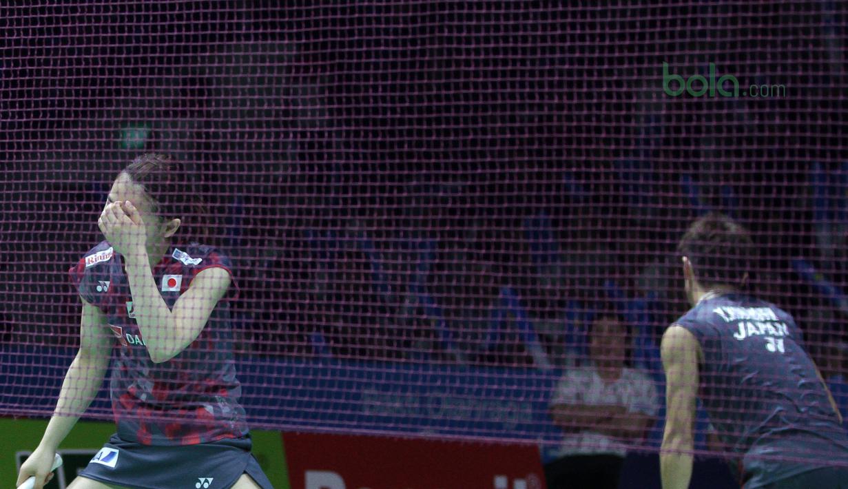 Misaki Matsutomo menutup wajahnya setelah gagal mengembalikan kok ke arah Tontowi Ahmad/Liliyanan Natsir pada babak kedua Indonesia Open 2018 di Istora Senayan, Jakarta, (5/6/2018). Tontowi/Liliyana menang 24-22, 21-19. (Bola.com/Nick Hanoatubun)