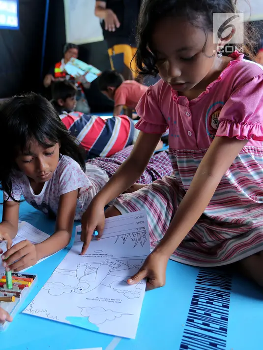 Anak-anak korban gempa tsunami Palu sedang mewarnai di halaman kantor Dinas Sosial Palu, Sulawesi Tengah, Sabtu (6/10). Trauma healing diberikan untuk mencegah anak memiliki kepribadian buruk. (Liputan6.com/Fery Pradolo)