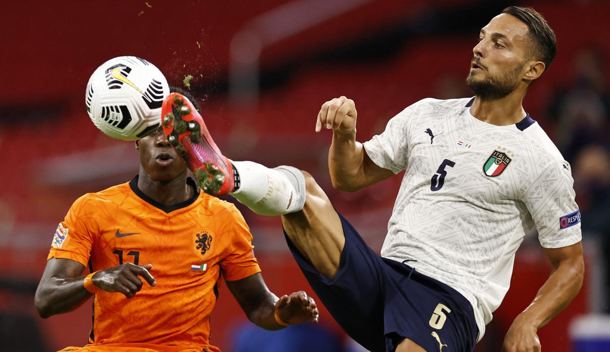 Bek Italia, Danilo D'Ambrosio, berebut bola dengan penyerang Belanda, Quincy Promes, pada laga UEFA Nations League di Amsterdam Arena, Selasa (8/9/2020) dini hari WIB. Italia menang tipis 1-0 atas Belanda. (AFP/Maurice Van Steen/ANP)