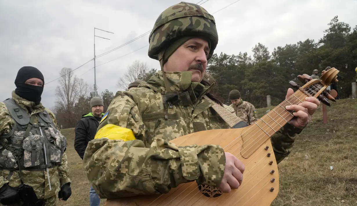 Taras Kompanichenko, seniman terkenal Ukraina dan relawan Pasukan Pertahanan Teritorial, memainkan kobza, alat musik gesek rakyat, pada upacara pernikahan Lesia Ivashchenko dan Valerii Fylymonov di pos pemeriksaan di Kiev, 6 Maret 2022 (AP/Efrem Lukatsky)