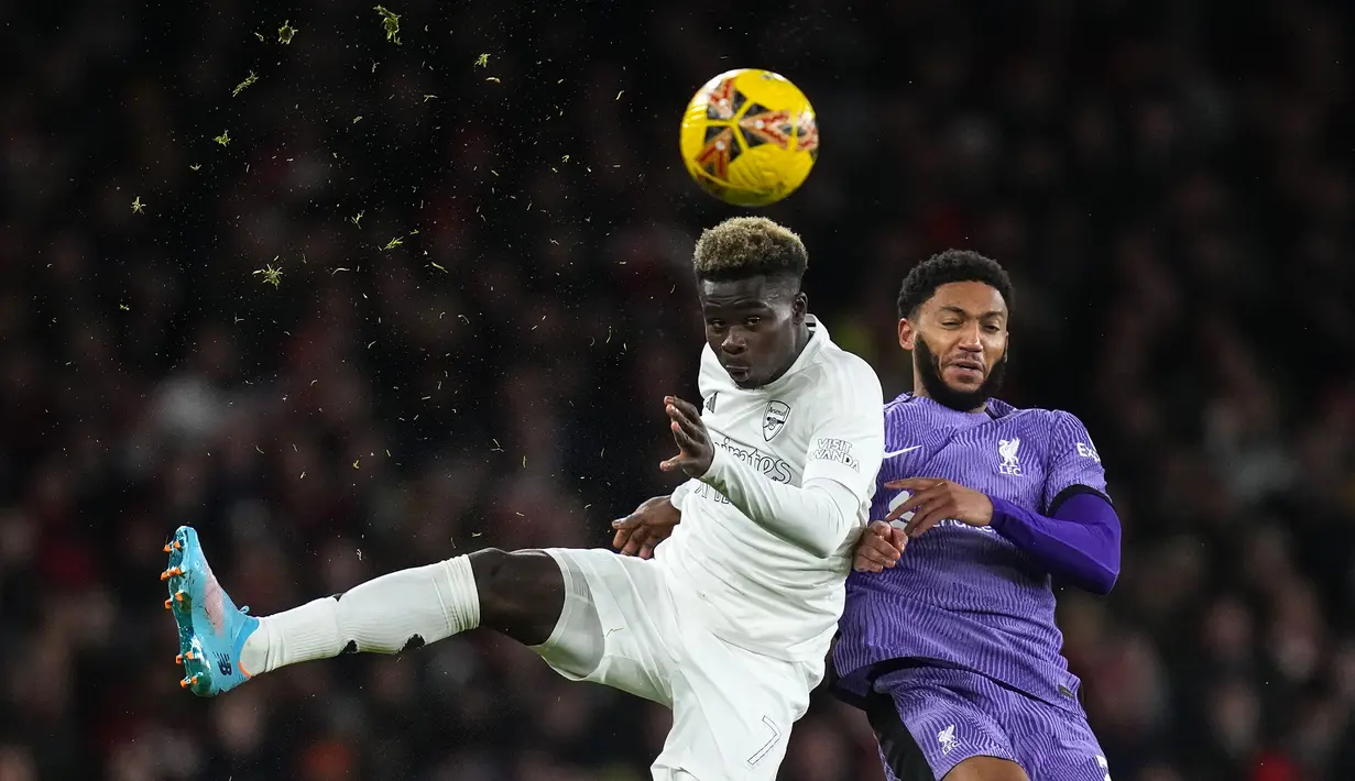 Pemain Arsenal, Bukayo Saka (kiri) berebut bola dengan pemain Liverpool, Joe Gomez saat laga putaran ketiga Piala FA 2023/2024 di Emirates Stadium, London, Inggris, Minggu (07/01/2024) WIB. Ini merupakan musim ketiga Arsenal menggunakan seragam yang meniadakan warna merah tradisional klub sejak 2022. (AP Photo/Kirsty Wigglesworth)