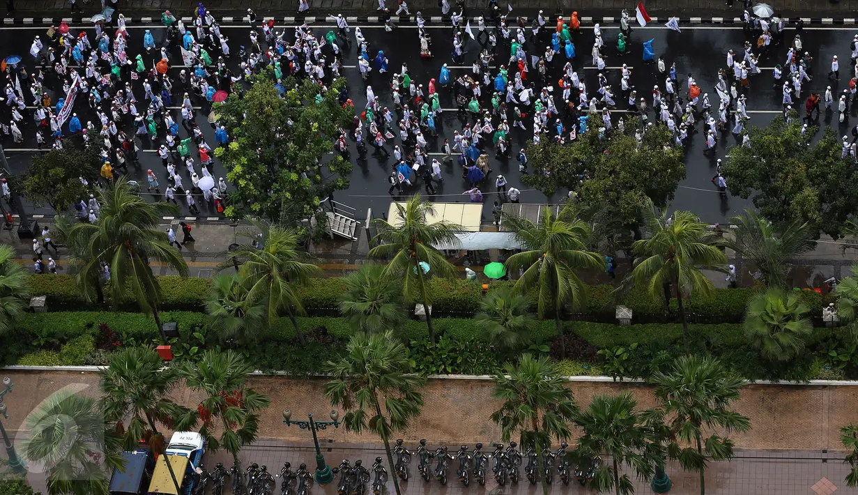 Setelah menunaikan ibadah Salat Jumat di Monas, Jakarta, massa aksi 2 Desember mulai membubarkan diri dengan tertib, Jumat (2/12). Massa yang sudah basah kuyup akibat kehujanan memilih kembali pulang ke rumah masing-masing. (Liputan6.com/Johan Tallo)