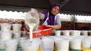 Seorang wanita menyiapkan Bubur Lambuk di desa Kampung Baru, Kuala Lumpur, Malaysia, Kamis (1/6). Bubur Lambuk adalah bubur yang terbuat dari beras dengan campuran rempah dan sayuran. (AP/Daniel Chan)