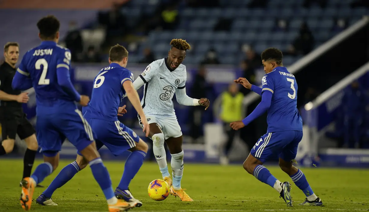 Penyerang Chelsea, Tammy Abraham berusaha melewati tiga pemain Leicester City pada pertandingan lanjutan Liga Inggris di Stadion King Power, Rabu (20/1/2021). Dengan kemenangan ini, Leicester City sementara meraih puncak klasemen Liga Inggris.  (Tim Keeton/Pool via AP)