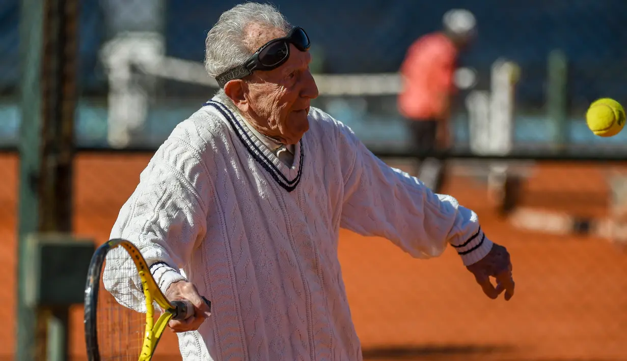 Artyn Elmayan, seorang pria asal Armenia, bermain tenis di River Plate Club di Buenos Aires, Selasa (16/5). Meski usianya telah mencapai 100 tahun, Artyn mengaku tetap rutin main tenis tiga kali seminggu. (AFP FOTO / Eitan ABRAMOVICH)