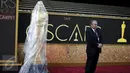 Seorang penjaga keamanan berdiri di samping patung Oscar yang ditutupi plastik pada pintu masuk ke teater Dolby saat persiapan ke-88 Academy Awards di Hollywood, Los Angeles , California, (27/2). (REUTERS / Lucy Nicholson)