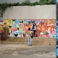Warga melihat mural yang menghiasi tembok dalam acara Mural Cikini Project #1 di Taman Plaza Teater Besar, Taman Ismail Marzuki, Jakarta, Jumat (23/8/2019). Project #1/Mural Cikini yang diikuti oleh 4 seniman digelar dalam rangka menata estetika ruang publik. (Liputan6.com/Faizal Fanani)
