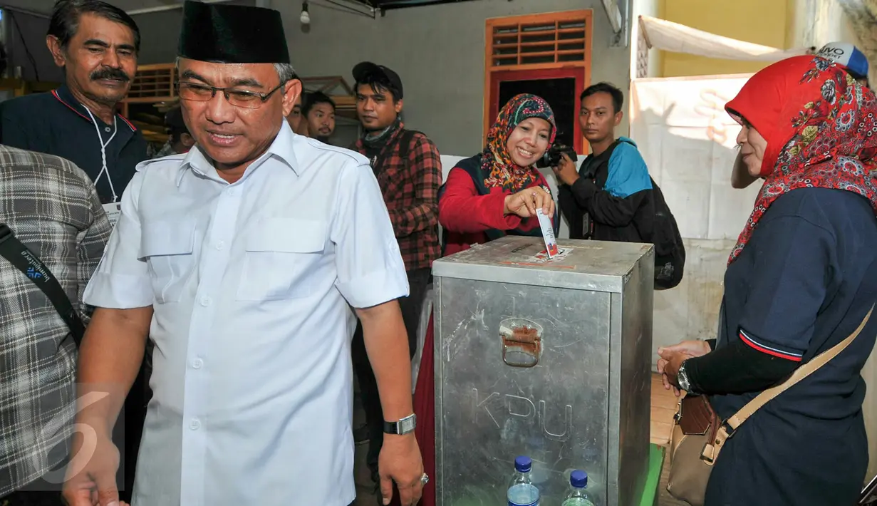 Calon Walikota Depok, Mohammad Idris dan istri usai memasukkan surat suara kedalam kotak di TPS 077 di Perum Pondok Duta, Depok, (9/12). Mohammad Idris diusung oleh Partai Keadilan Sejahtera (PKS) dan Partai Gerindra. (Liputan6.com/Yoppy Renato)