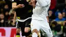 Gelandang Real Madrid, Casemiro (kanan) berebut bola dengan gelandang Sevilla, Iborra pada Liga Spanyol di Stadion Santiago Bernabeu (21/3). Real Madrid menang besar atas Sevilla dengan skor 4-0. (AFP/PIERRE-PHILIPPE Marcou)