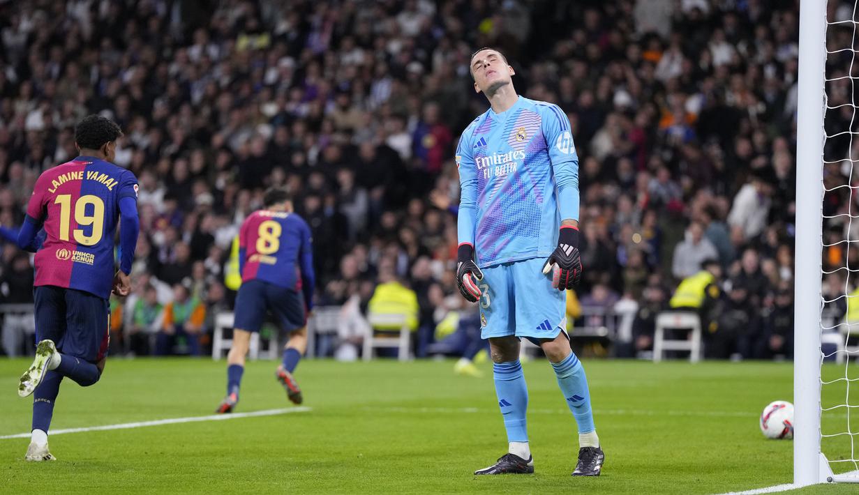 Kiper Real Madrid, Andriy Lunin tak kuasa menahan rasa kecewa setelah gawangnya dibobol oleh pemain Barcelona pada laga lanjutan Liga Spanyol 2024/2025 di Santiago Bernabeu, Madrid, Spanyol, Minggu (27/10/2024) WIB. (AP Photo/Manu Fernandez)