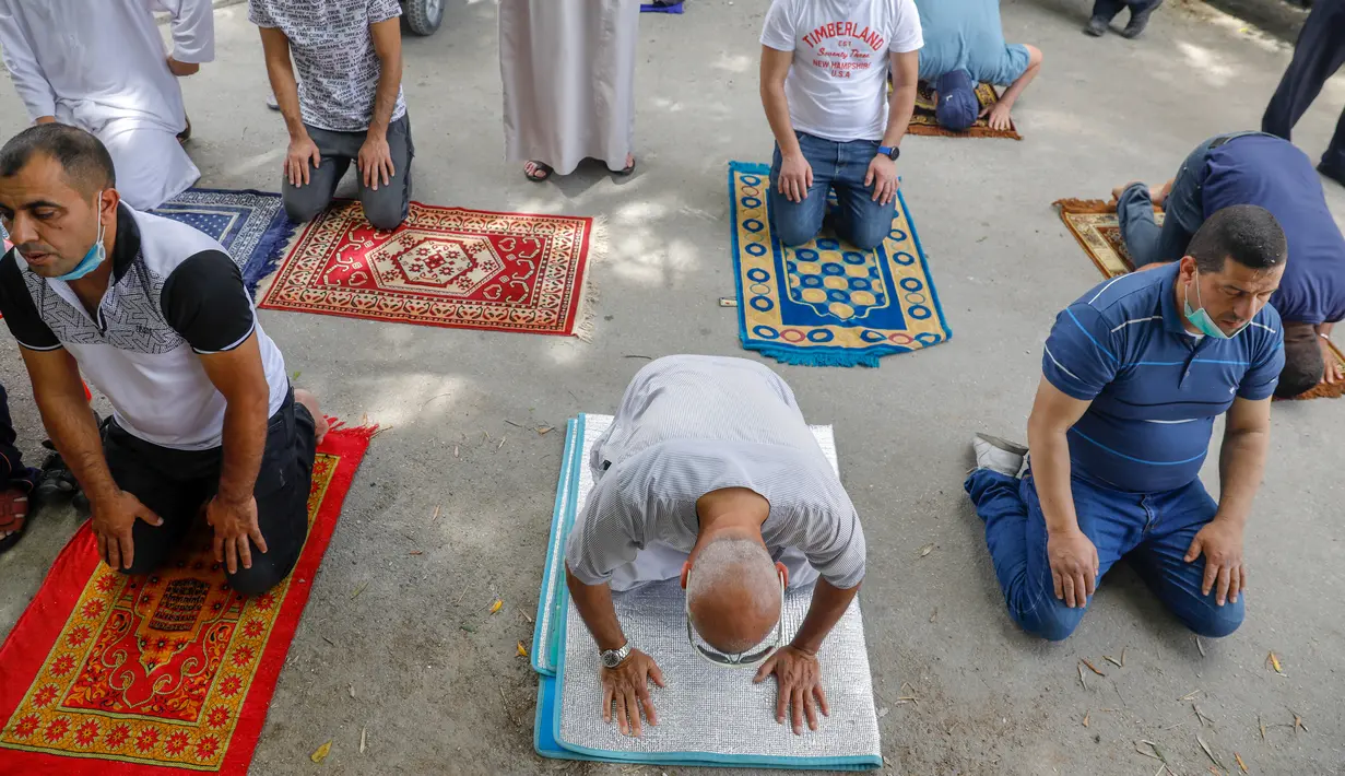 Para jemaah Palestina melaksanakan salat Jumat selama bulan suci Ramadan di tengah krisis pandemi coronavirus di luar kompleks masjid al-Aqsa di Kota Tua Yerusalem (15/5/2020). (AFP/Ahmad Gharabli)