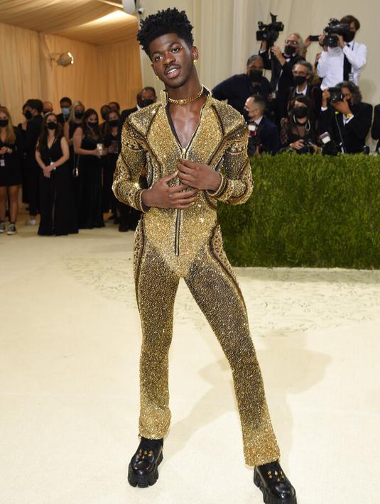 Penampilan rapper Lil Nas X menghadiri The 2021 Met Gala Celebrating In America: A Lexicon Of Fashion di Metropolitan Museum of Art, New York City, Senin (13/9/2021). Lil Nas X yang hadir di Met Gala 2021 dengan penuh totalitas tampil menggunakan 3 busana sekaligus. (Evan Agostini/Invision/AP)