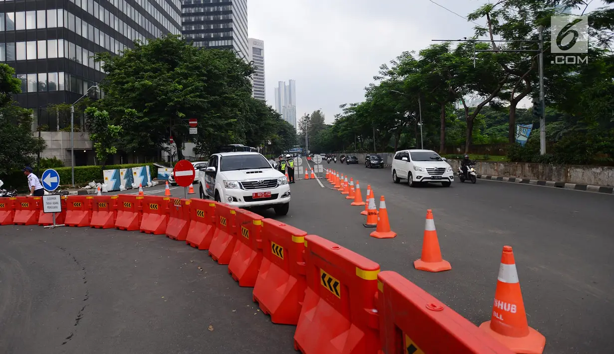 Petugas berjaga saat uji coba sistem satu arah di kawasan Dukuh Bawah atau sekitar Landmark Setiabudi, Jakarta, Rabu (13/2). Sistem satu arah dilakukan dalam rangka penataan Transit Oriented Development (TOD) Dukuh Atas. (Merdeka.com/Imam Buhori)