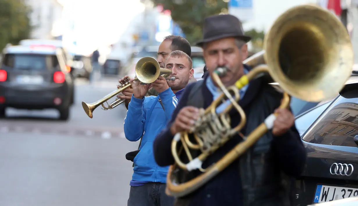 Orkes tiup musisi Rumania menghibur pejalan kaki untuk mendapat uang di Warsawa, Polandia pada 21 Oktober 2019. Orkes tiup yaitu sekelompok orang yang memperagakan musik dengan menggunakan instrumen musik tiup baik tiup logam maupun tiup kayu.  (AP Photo/Czarek Sokolowski)
