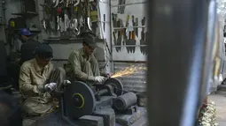Pedagang membuat pisau untuk ritual pencambukan diri umat Syiah di sebuah toko di Pakistan (18/9). Hari Ashura menandai kesyahidan tujuh-abad cucu Nabi Muhammad, Imam Hussein yang tewas dalam pertempuran di Karbala, Irak 680 AD. (AFP Photo/Arif Ali)